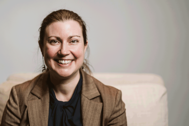 Woman smiling with brown jacket and brown hair