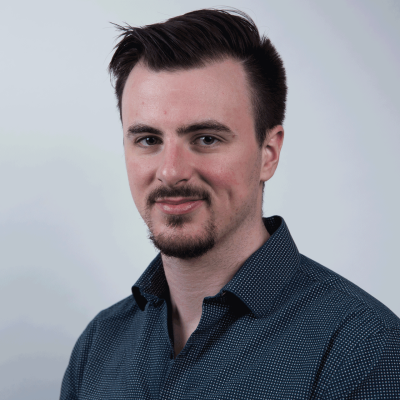 Man with dark hair and goatee, wearing a blue button up shirt